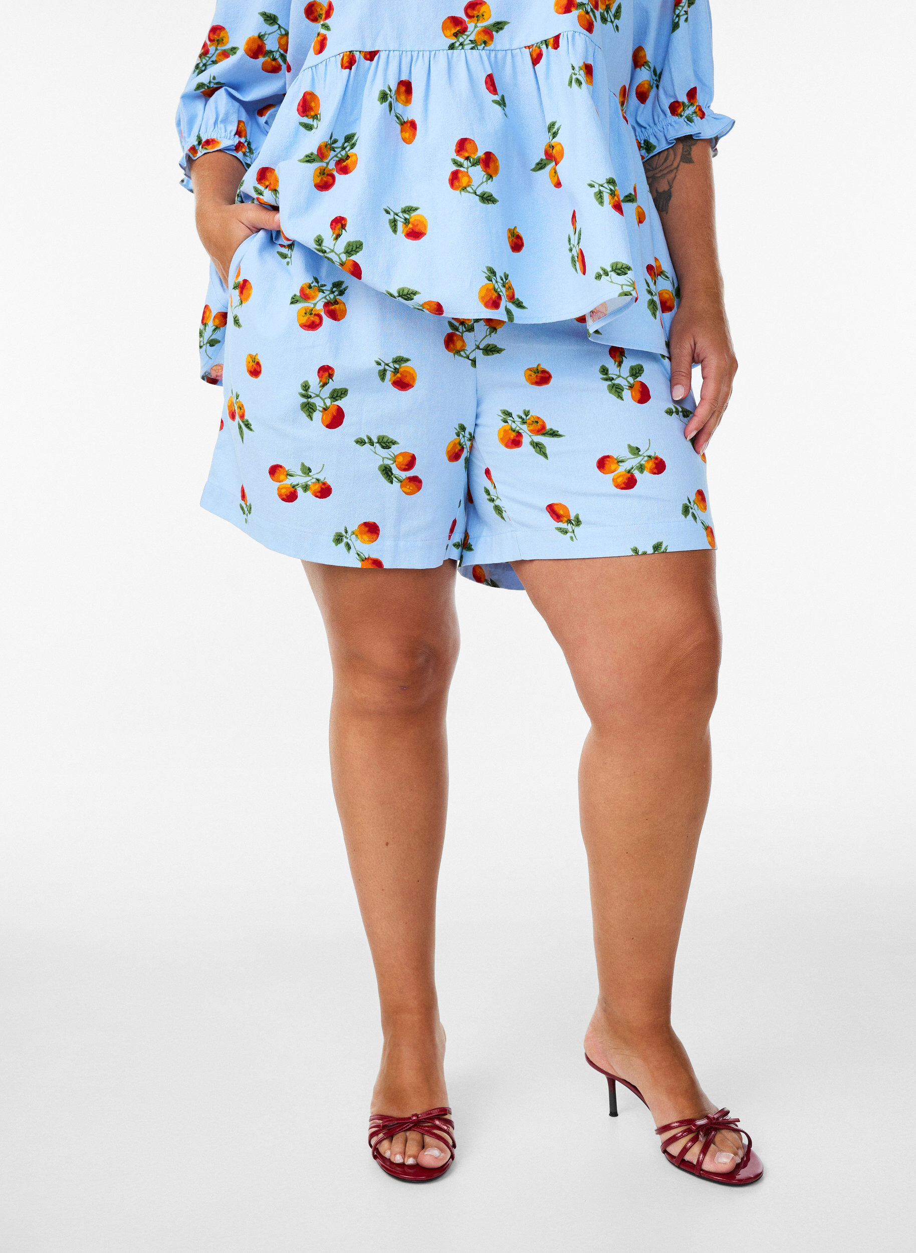 Puuvillashortsit tomaattiprintill&auml; ja korkealla vy&ouml;t&auml;r&ouml;ll&auml;, Sininen, Model