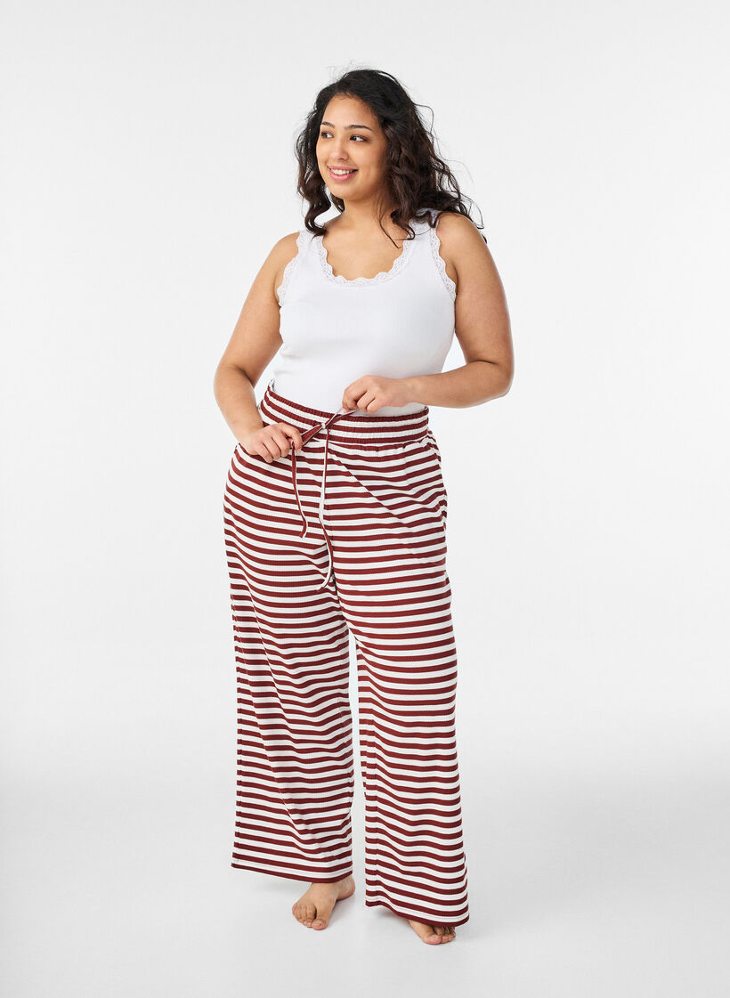 Raidalliset pyjamahousut korkealla vy&ouml;t&auml;r&ouml;ll&auml; ja leveill&auml; lahkeilla, Punainen, Model image number 0
