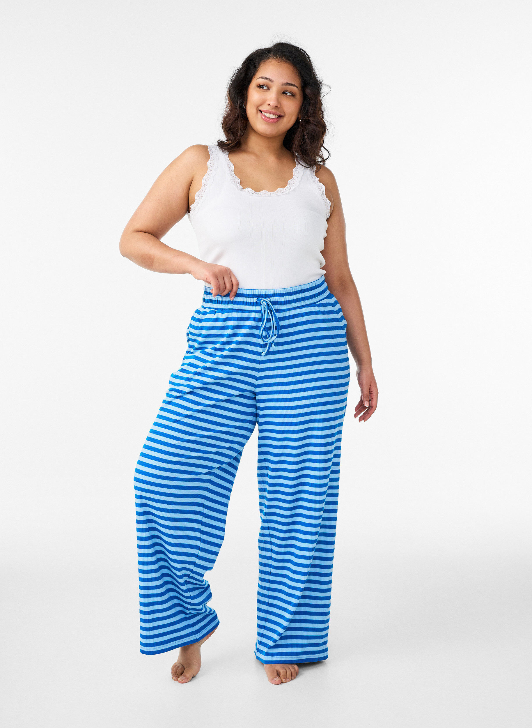 Raidalliset pyjamahousut korkealla vy&ouml;t&auml;r&ouml;ll&auml; ja leveill&auml; lahkeilla, Sininen, Model