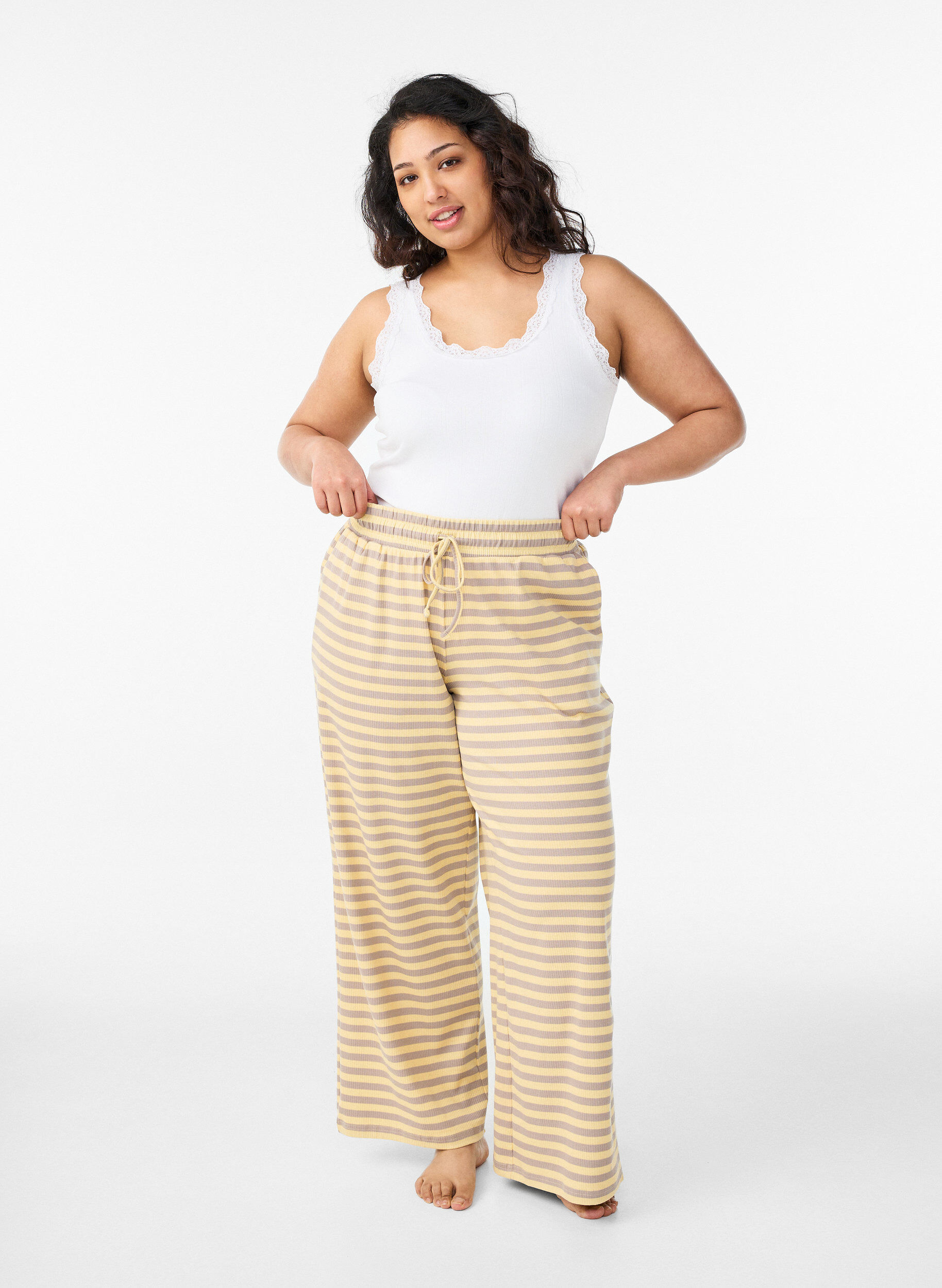 Raidalliset pyjamahousut korkealla vy&ouml;t&auml;r&ouml;ll&auml; ja leveill&auml; lahkeilla, Keltainen, Model